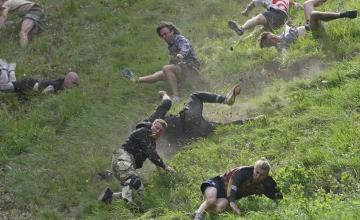 IN A CHAOTIC UK RACE, COMPETITORS CHASE A CHEESE WHEEL DOWN A HILL