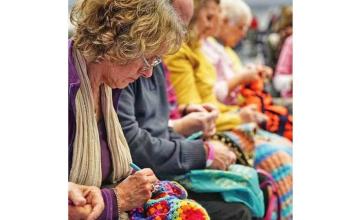 960 PEOPLE CROCHET IN A BRITISH ARENA, BREAKING A WORLD RECORD.